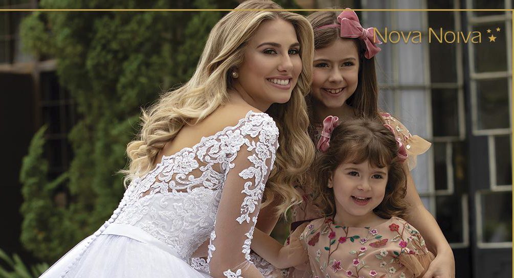 Vestido rodado com decote bateau e mangas longas; Vestido em net paetizada, sobreposta por tule com barrado e aplicações de renda fio de seda, bordadas com pedrarias diversas; Cinto com laço, fixo; Transparência branca. [ngg src=”galleries” ids=”19″ display=”basic_thumbnail”]