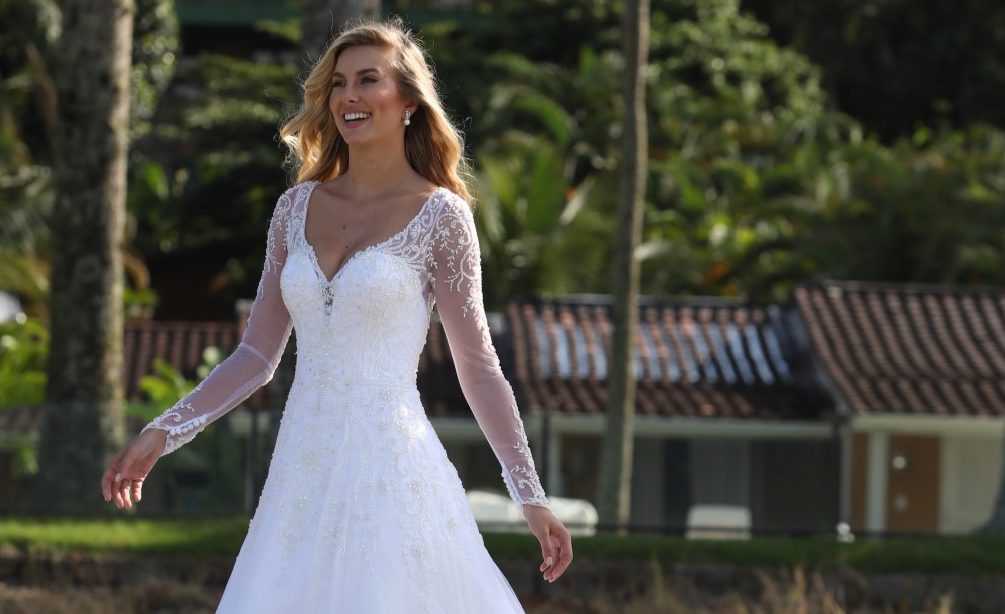 Vestido rodado com decote princesa e manga longa; Vestido em tule high gloss (alto brilho) sobreposto por tule com barrado de crinol; Corpo bordado com pedrarias diversas. [ngg src=”galleries” ids=”5″ display=”basic_thumbnail” thumbnail_crop=”0″]